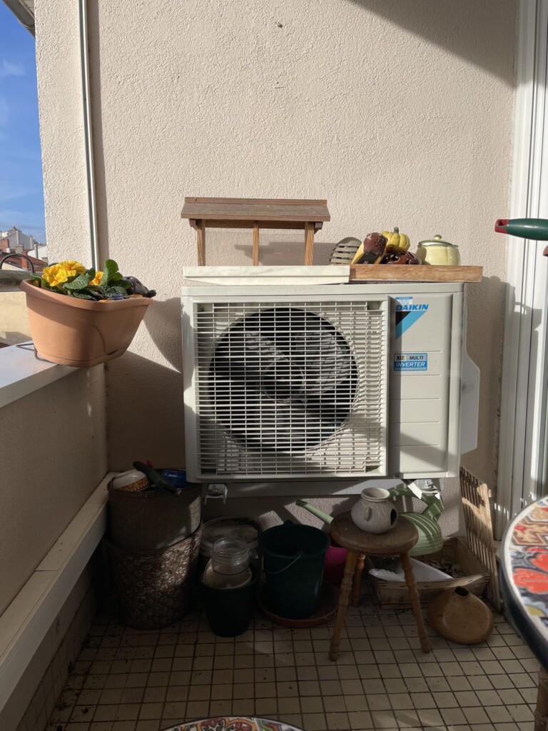 Bloc de climatisation apparent sur un balcon à Lyon 7 avant la pose du cache en bois