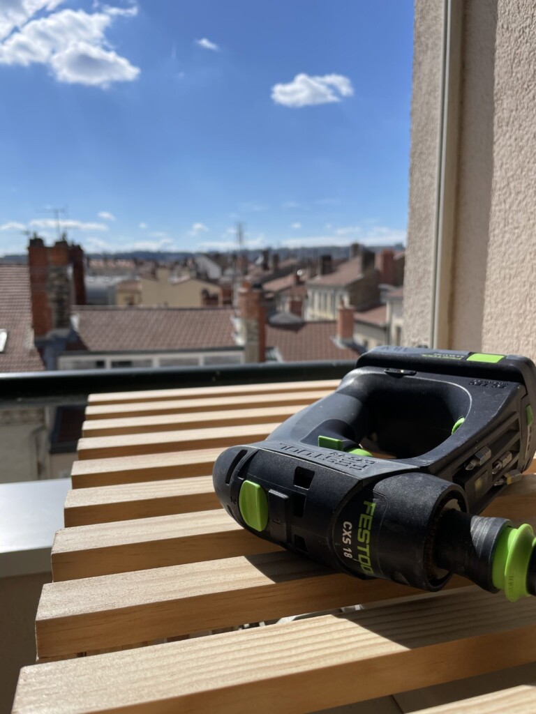 Assemblage des lattes de pin du Nord du cache, en cours de montage sur le balcon