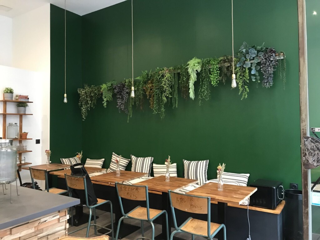 Coin banquette du coffee shop Lyon 2, banquette sur-mesure et mur végétal