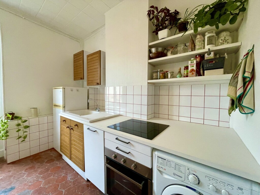 Cuisine rénovée à Lyon 3, meubles blancs et faïence à joint terracotta