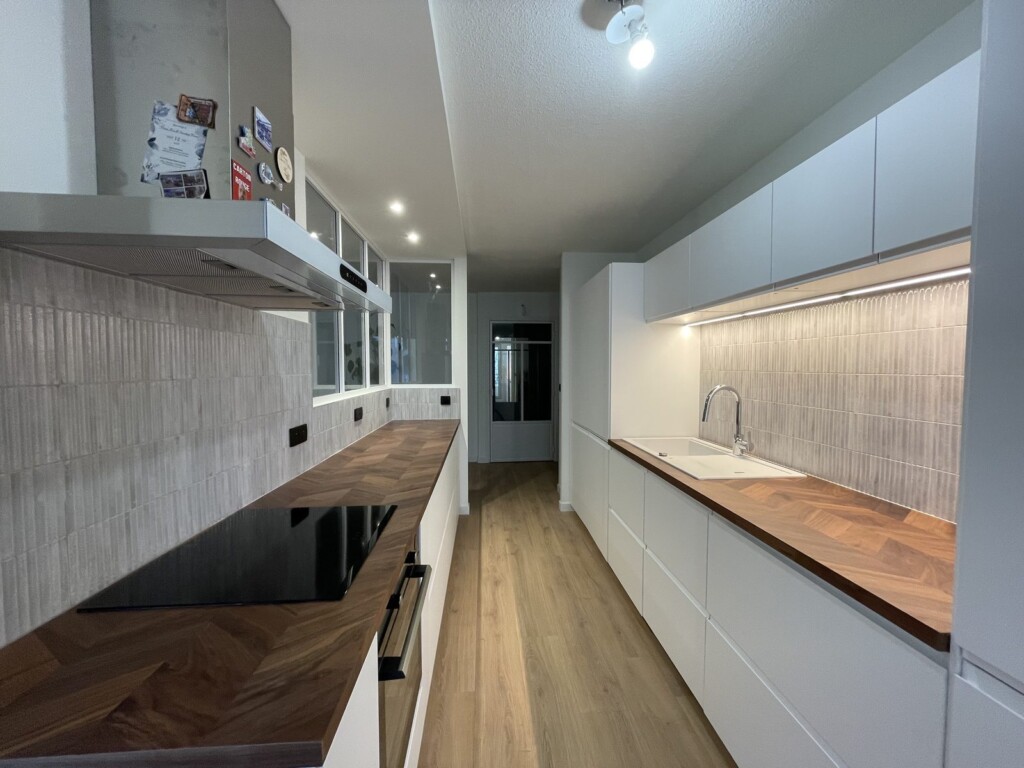 Cuisine avec crédence en carrelage cannelé minéral et plan de travail en noyer à Lyon 6 Brotteaux, après