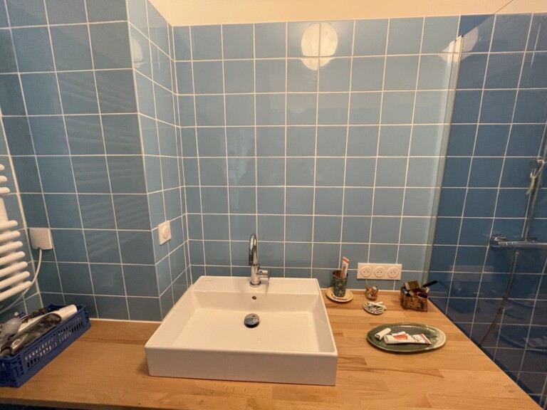 Mur carrelé au-dessus du lavabo avant la pose du grand miroir sur-mesure, salle de bain à Lyon 7