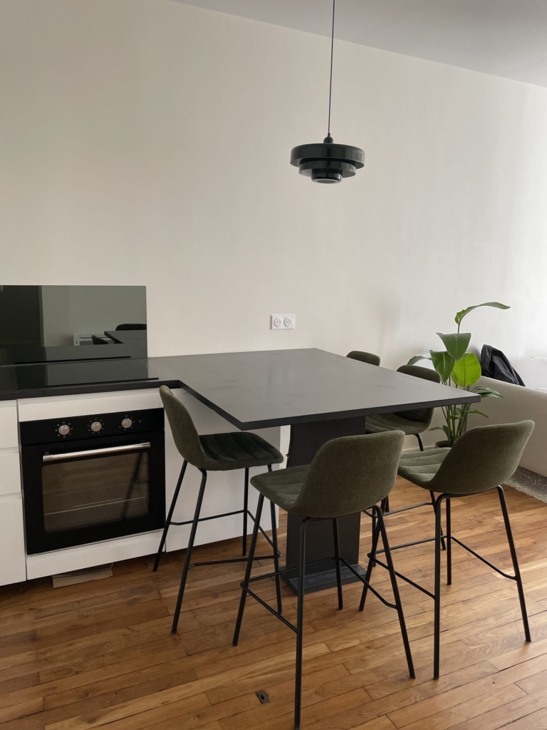 Pièce de vie rénovée avec cuisine ouverte et table haute, Lyon