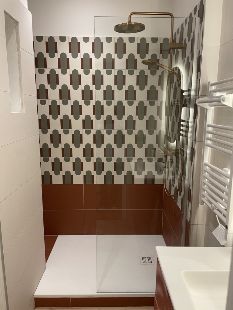 Salle de bain rénovée à Lyon 7, carrelage à motifs et robinetterie laiton