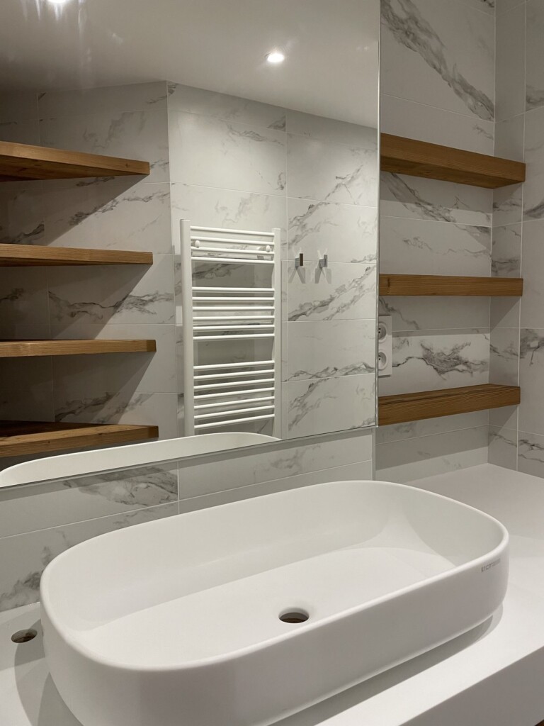 Salle de bain rénovée, carrelage effet marbre et étagère en bois à lattes
